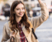 young woman smiles and waves at neighbor