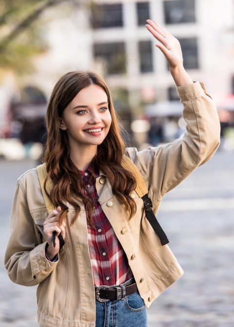 young woman smiles and waves at neighbor