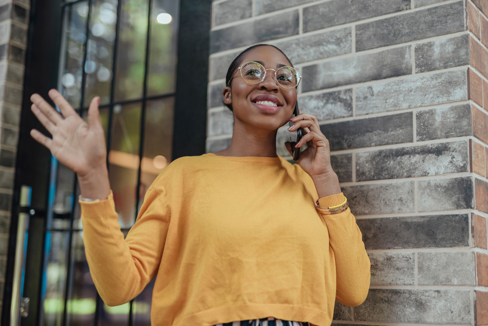 waving hello young african american woman waves hello to neighbor